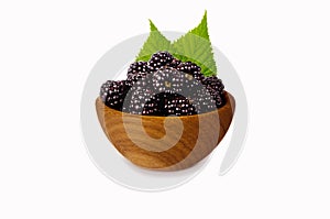 Blackberries on a wooden bowl isolated on white.