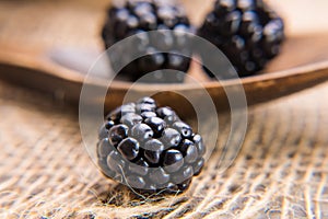 Blackberry close-up on the background of a wooden spoon  with blackberries