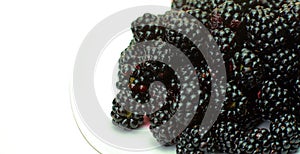 BlackBerry close-up. On the plate lies a black BlackBerry as a background