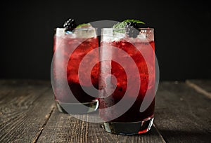 Blackberry cocktail with crushed ice on the rustic wooden background. Selective focus. Shallow depth of field