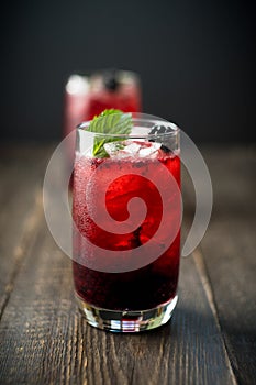 Blackberry cocktail with crushed ice on the rustic wooden background. Selective focus. Shallow depth of field