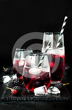 Blackberry drink in glasses with black sugar rim for fall and halloween parties.