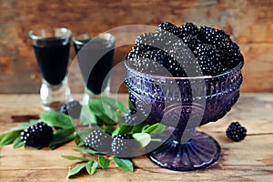 Blackberry fruit liqueur in two shot glasses with berries and gr