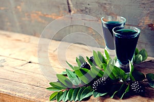 Blackberry fruit liqueur in two shot glasses with berries and gr