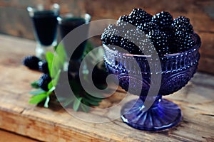 Blackberry fruit liqueur in two shot glasses with berries and gr