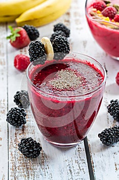 Blackberry and raspberry smoothies garnished with chia seeds and fresh fruit.