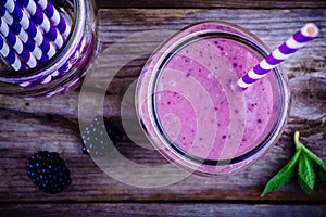 Blackberry smoothie in a mason jar on a wooden background