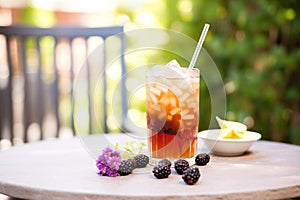 blackberry tea with ice, blackberries top, outdoor table
