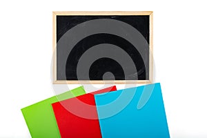 blackboard and colored notebooks