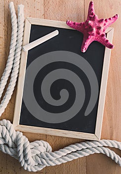 Blackboard decorated by ropes and red starfish