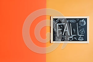 Blackboard with handwritten text `Fall` on orange background