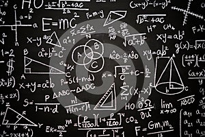 Blackboard inscribed with scientific formulas and calculations in physics, mathematics and electrical circuits. Science and