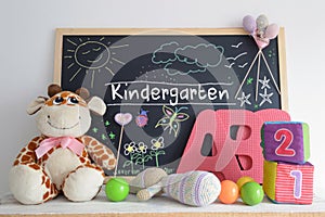 Blackboard in a kindergarten classroom and some baby stuff.