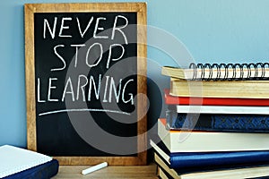 Blackboard with Never stop learning and books.
