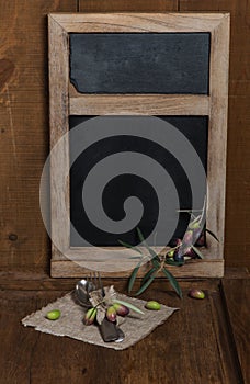 Blackboard with olives and tableware