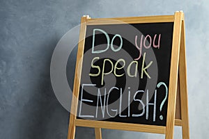 Blackboard with question Do You Speak English on grey background