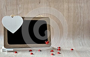 Blackboard with red ladybugs and white heart