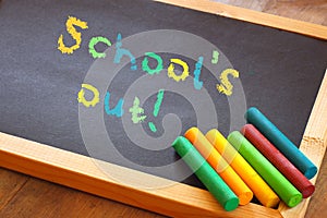 Blackboard with schools out text written in colorful letters