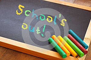 Blackboard with schools out text written in colorful letters photo