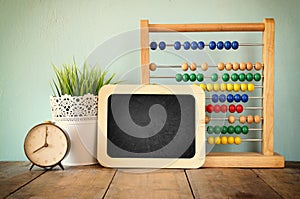 Blackboard, stack of colorful beaded abacus and clock. back to school concept