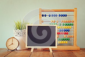 Blackboard, stack of colorful beaded abacus and clock. back to school concept