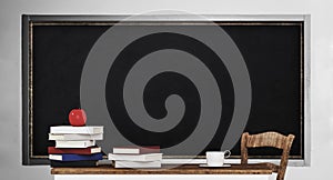 Blackboard, table, pile of books and apple, in classroom