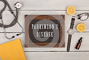 blackboard with text & x22;Parkinson& x27;s disease& x22;, book, stethoscope and watch