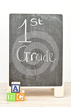 A blackboard with the words 1st grade with alphabet blocks