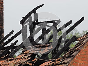 Blackened roof rafters of a burned down residential building after a fire