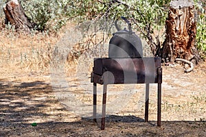 blackened, soot-covered kettle for boiling water on the grill