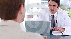 Blackhaired doctor talking with his patient