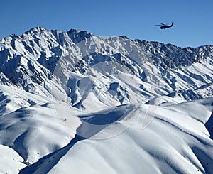 Blackhawk over snowy Afghanistan Mountains photo