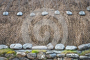 Blackhouse thatched roof detail with thatch, stone and rope photo