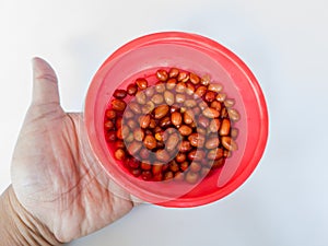 Blackish brown fried peanuts in a red container