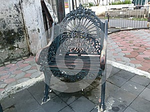 blackish gray iron garden chair on the roadside sidewalk