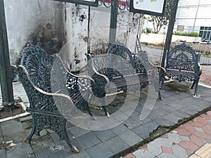 blackish gray iron garden chair on the roadside sidewalk