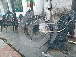 blackish gray iron garden chair on the roadside sidewalk