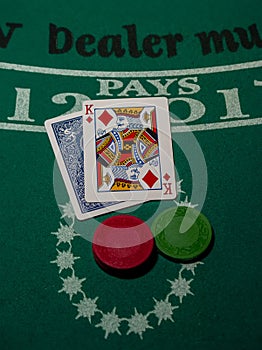 Blackjack cards with a king face up on a backjack table