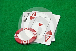 Blackjack hand with casino chip on green table