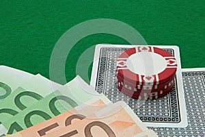 Blackjack hand with Euro notes and chips on green