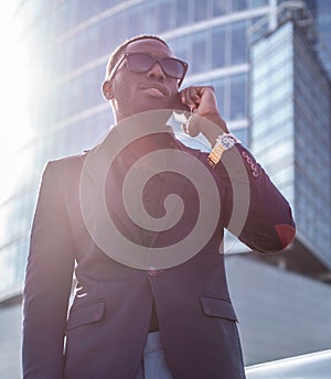 A blackman in a suit speaking on smartphone. photo