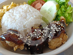 blackpepper chicken served simply on the table decorated with tomatoes and lettuce photo