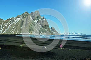 Blacksand beach with mountains in the background