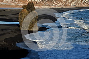 Blacksand beach with rocks in Iceland photo