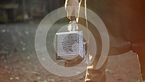 blacksmith or fairy-tale character in leather apron holds fantastic fantasy huge hammer in his hands. Sun shine in