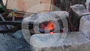 Blacksmith forge welding a hot steel horseshoe with a hammer