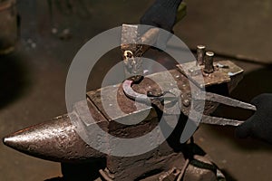 Blacksmith forges a horseshoe, close-up