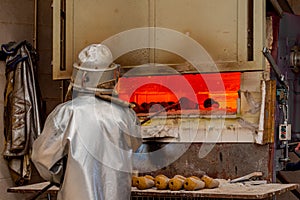 Blacksmith forging cowbells in the oven back