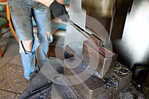 Blacksmith forging by using pneumatic hammer.