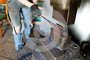 Blacksmith forging by using pneumatic hammer.